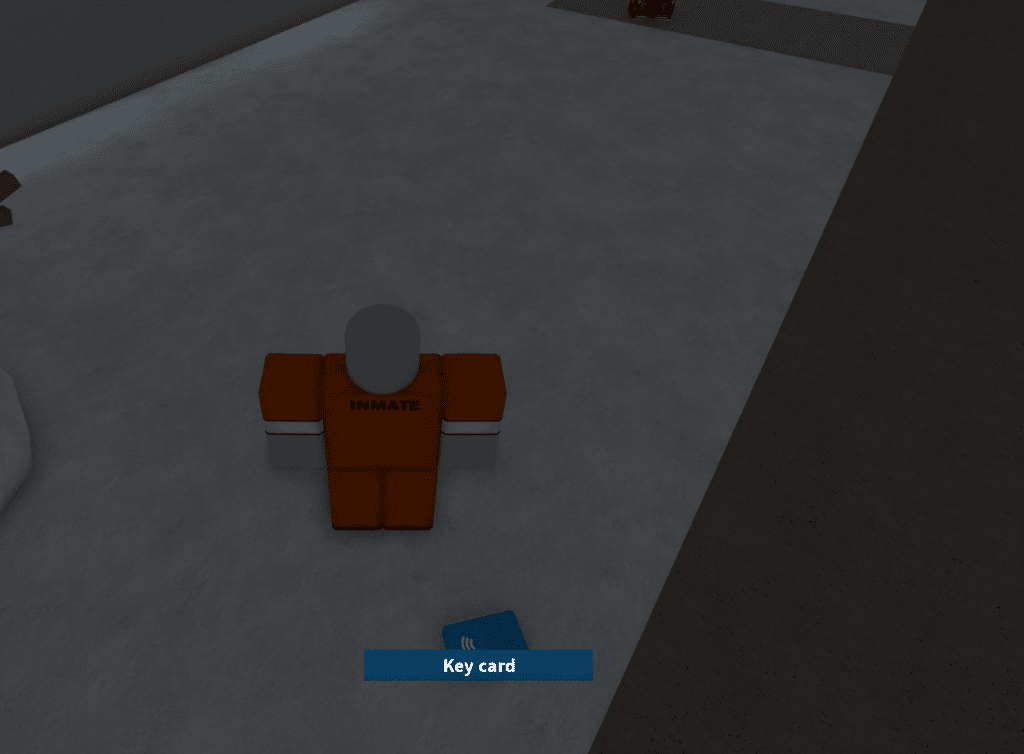 A blue electronic Key card lying on the grey concrete floor of the prison yard